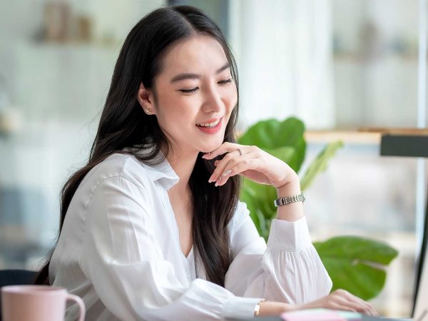 Woman smiling while looking at a laptop screen