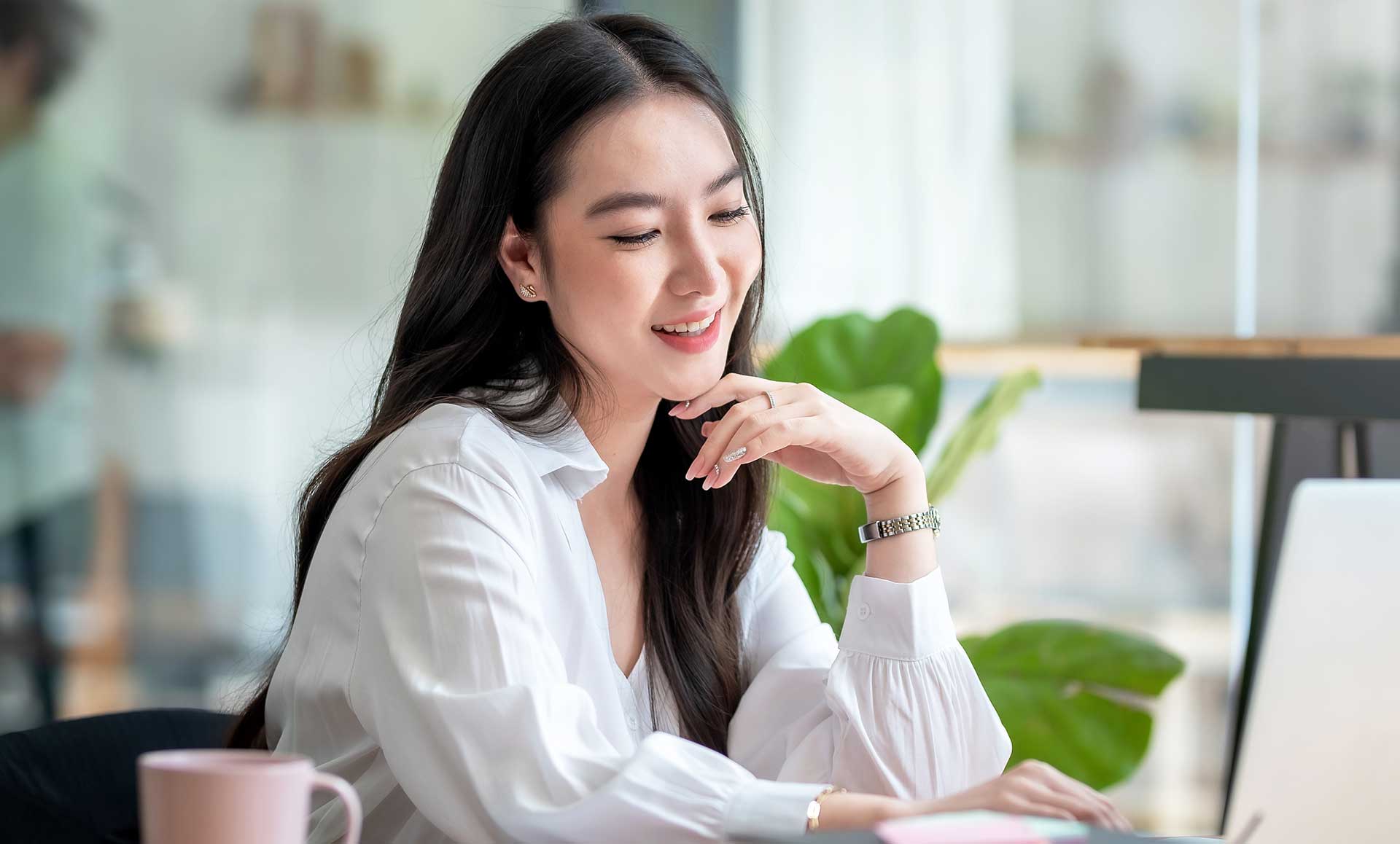 Woman smiling while looking at a laptop screen