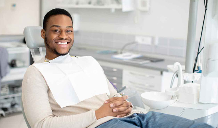 Man smiling in a clinic, representing SLB dental care.
