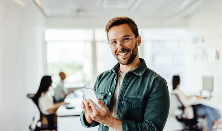Happy man holding a phone, symbolizing enrolling changes.