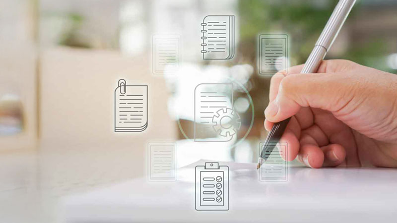 Person writing on papers, representing forms, plans, and documents.