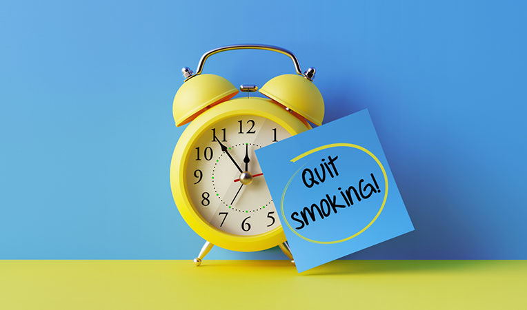 Clock with a handwritten note reading "Quit smoking