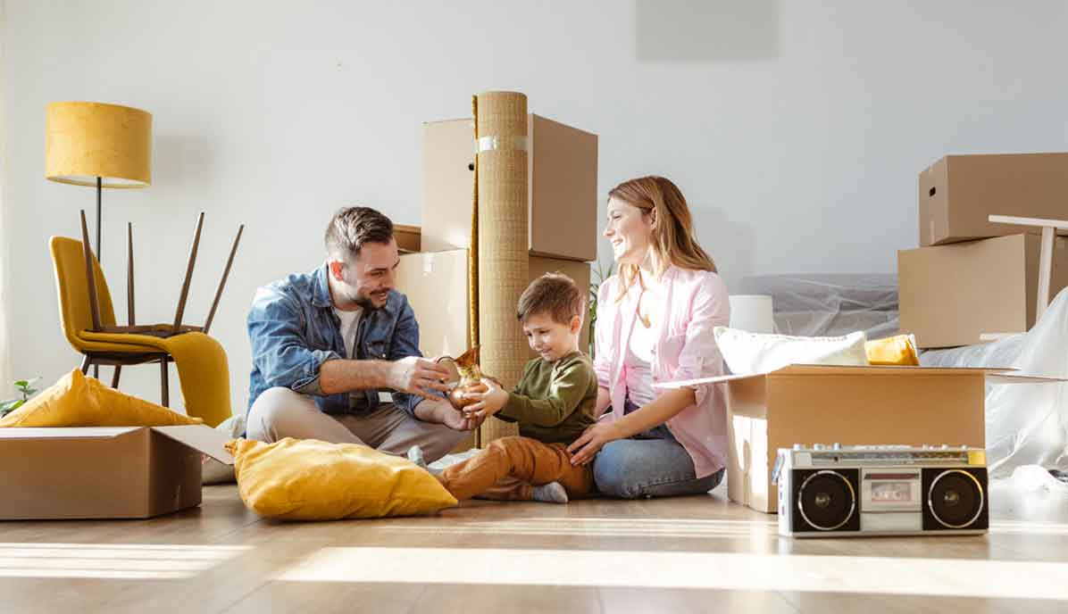 Shot of a happy family unpacking boxes and talking to the child while sitting on the floor.