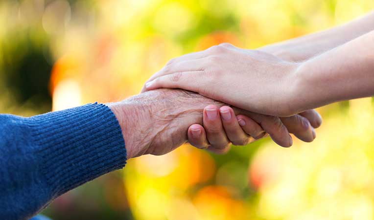 Shot of holding hands signifies concept of care