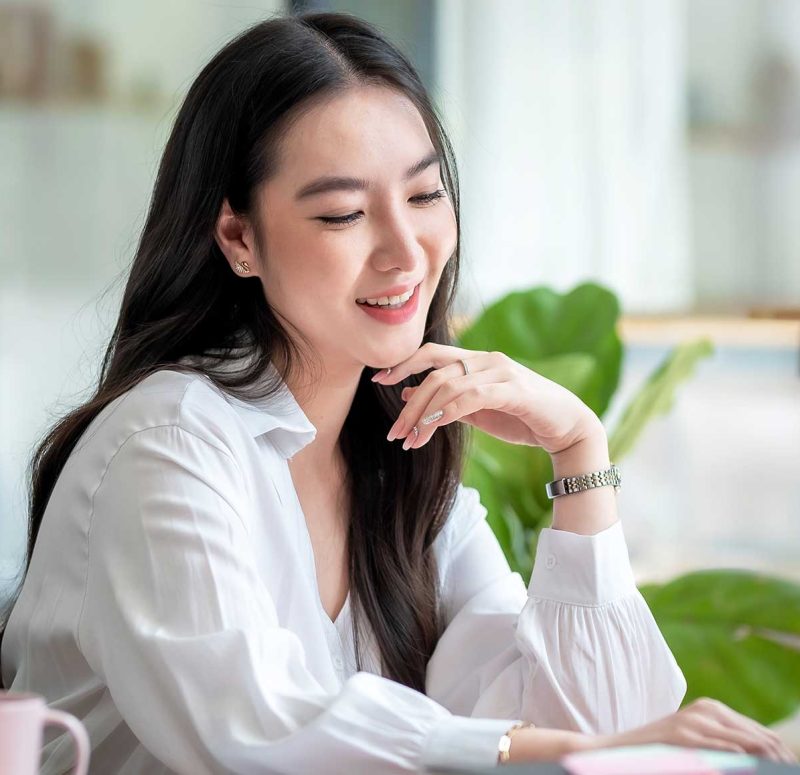 Woman smiling while looking at a laptop screen